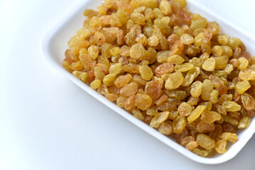 Juicy yellow raisins on a white backing