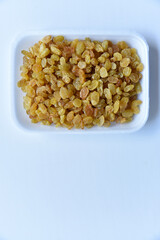 Juicy yellow raisins on a white backing