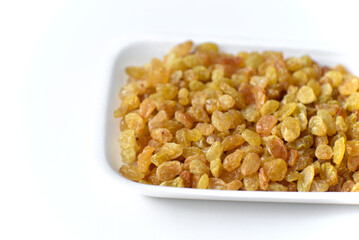 Juicy yellow raisins on a white backing