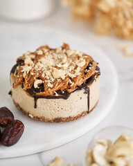 Delicate caramel mousse cake glazed with chocolate and covered with caramel and nuts on the top. Side view.           