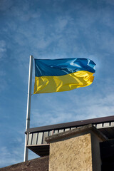 The flag of ukraine waving in the wind against the blue sky background