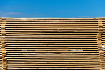 Wooden boards for construction stacked outdoors under a bare sky, horizontally, building material