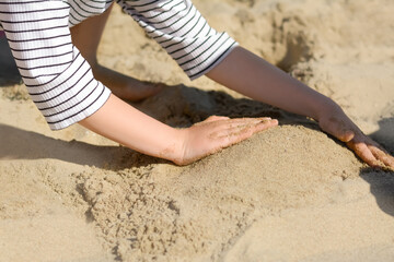 Child making sand castle on beach, closeup