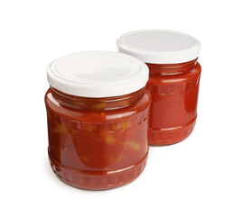 Glass jars of delicious canned lecho on white background