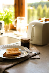 Tasty toasts and jar of jam on countertop in kitchen, space for text