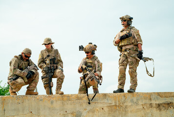 Military or soldier team with gun stay on concrete wall and prepare for battle with enemy in field...