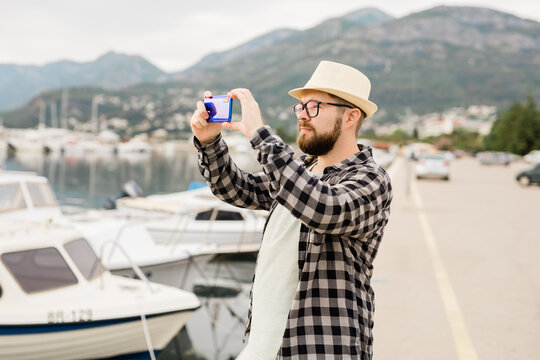 Traveller man taking pictures of luxury yachts marine during sunny day - travel and summer concept