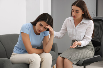 Professional psychologist working with young woman in office