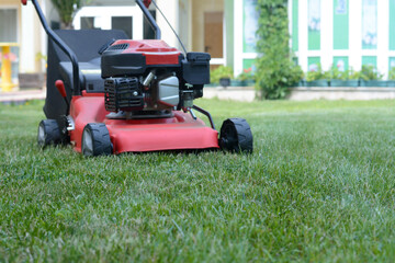 Modern garden lawn mower on green grass in park