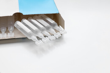 Package with single dose ampoules of sterile isotonic sea water solution on white background. Space...