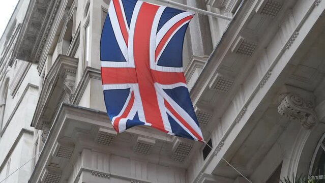 Slow Motion. Flag of the Great Britain hanging off the wall of a historic building.