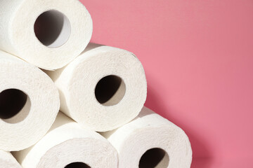 Many rolls of paper towels on pink background, closeup. Space for text