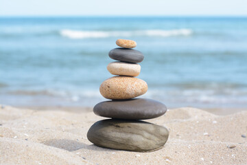 Fototapeta na wymiar Stack of stones on sandy beach near sea
