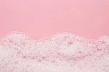 Fluffy bath foam on pink background, top view. Space for text - obrazy, fototapety, plakaty