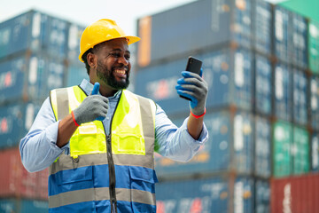 African American use mobile phone to talk with other also show thumbs up and express happiness in cargo container workplace area.