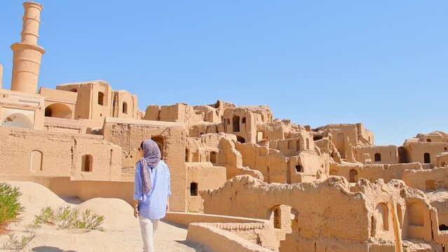 Tourist stand on viewpoint to Kharanaq village. Historical old clay buildings architecture in Iranian countryside
