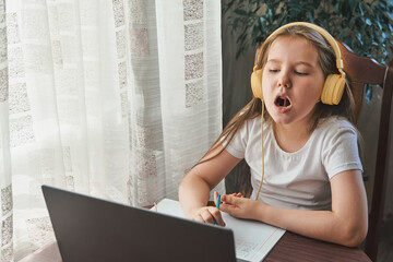 Speech training concept. Little girl uses a laptop to study at home with a teacher, a speech...