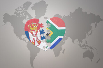 puzzle heart with the national flag of south africa and serbia on a world map background.Concept.