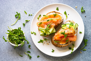 Open sandwich with salmon, cream cheese and cucumber. Healthy breakfast or snack. Top view with...