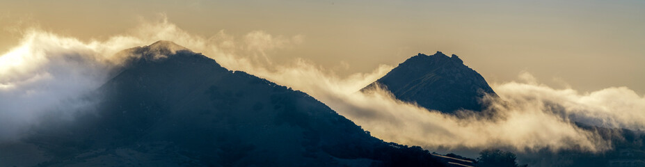 Panorama view of mountain peak, fog, clouds