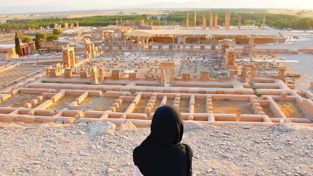 Female muslim tourist enjoy panorama of ancient city of Persepolis in Shiraz, Iran