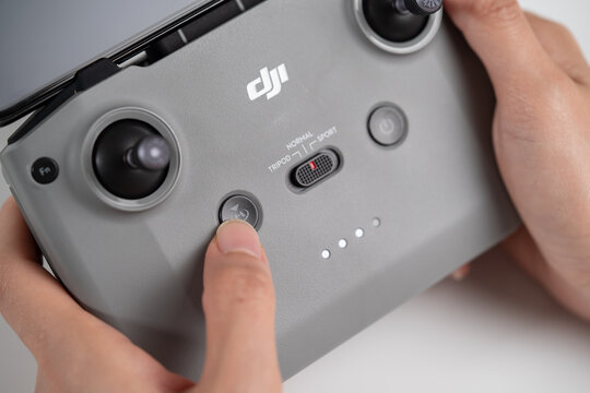 PENANG, MALAYSIA - JUL 08, 2020: Close up of the finger pressing the Return to Home (RTH) Button of the DJI Mavic Air 2 drone remore controller. DJI Mavic Air 2 open box and setup.