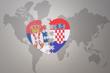 puzzle heart with the national flag of croatia and serbia on a world map background.Concept.