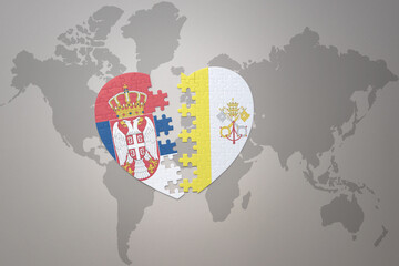 puzzle heart with the national flag of vatican city and serbia on a world map background.Concept.