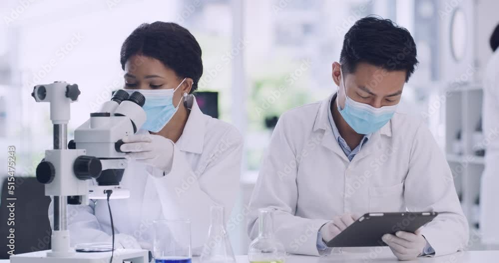 Poster Two medical scientists use a tablet and microscope while checking a virus sample inside a research facility. Specialists enter data into a system and analyze it on a petri dish to develop a cure