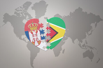 puzzle heart with the national flag of guyana and serbia on a world map background.Concept.