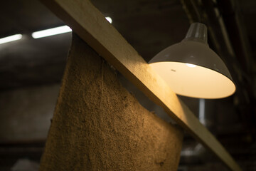 Lamp shines indoors. Interior in garage. Classic light source.
