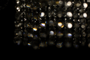 Texture of transparent glass in artificial light. Details of chandelier made of glass in dark.