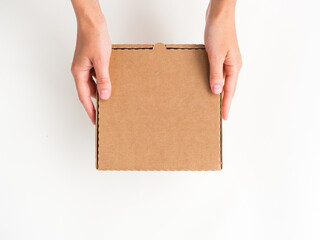 female hands give a small flat brown cardboard box on a white background. delivery and eco friendly...