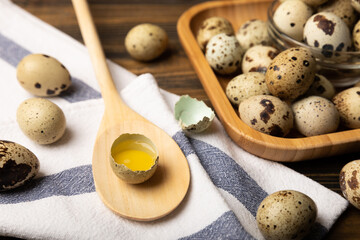 Quail eggs on brown texture background.Raw eggs. Broken quail egg. Natural products. Place for text. Fresh quail eggs.