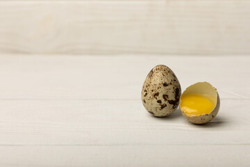Quail eggs on a white texture background. Whole and broken quail eggs. Natural products. Place for text. Fresh quail eggs.