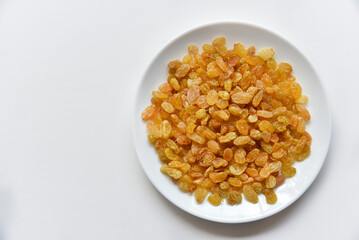 Yellow juicy raisins on a white plate
