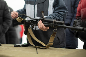 Children learn to shoot in Russia. Assembly of automatic weapons. Lesson in military training. Details of war training.