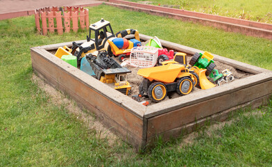 Children’s sandbox with toys on green grass
