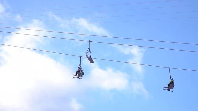 People ride the ski lift in the ski resort. side view.Mountains snow winter ski resort lift elevator