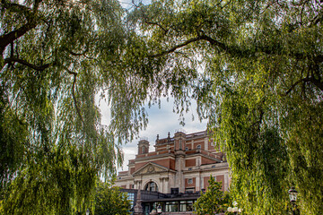 Weeping Willows Part and Offer a Peek-a-boo View of the Opera House from Kungsträdgården Park in Stockholm, Sweden