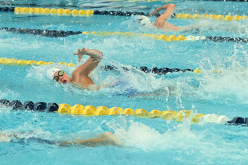 Young boy competing in a Swim Meet doing the breast stroke, butterfly, backstroke and freestyle