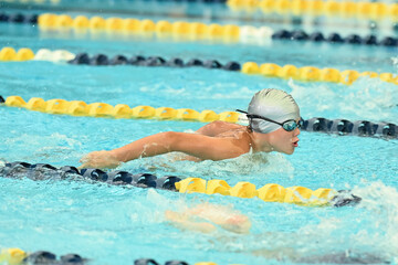 Young boy competing in a Swim Meet doing the breast stroke, butterfly, backstroke and freestyle