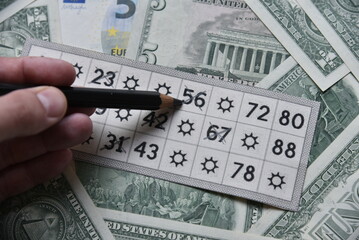 Dollar bills and lottery tickets with a pencil