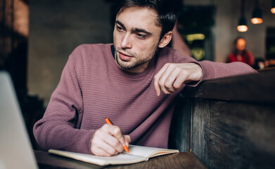 Intelligent student watching webinar video via laptop app using coworking internet connection...