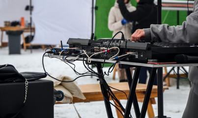 Closeup of hands of a female DJ mixing tracks and playing music at an outdoor concert