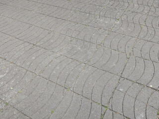sidewalk of grey tiles with a wave pattern