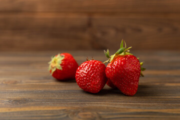 Fresh ripe strawberries on a brown texture background.Vegetarian organic berry.Healthy food.Copy space.Place for text