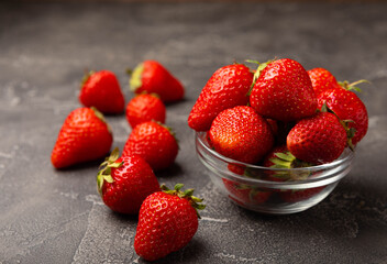 Fresh ripe strawberries in a plate on a black texture background.Vegetarian organic berry.Healthy food.Vitamins.Copy space.Place for text