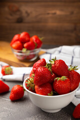 Fresh ripe strawberries in a plate on a black texture background.Vegetarian organic berry.Healthy food.Vitamins.Copy space.Place for text