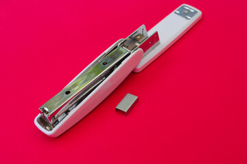 White stapler on magenta background